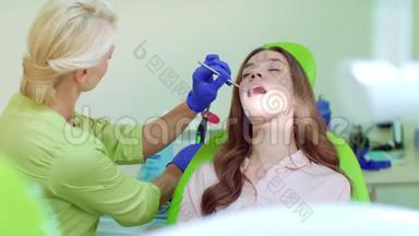 口腔用牙科治疗灯治疗口腔。 牙医和病人